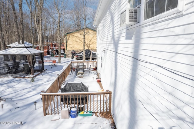 snow covered deck featuring area for grilling and a gazebo