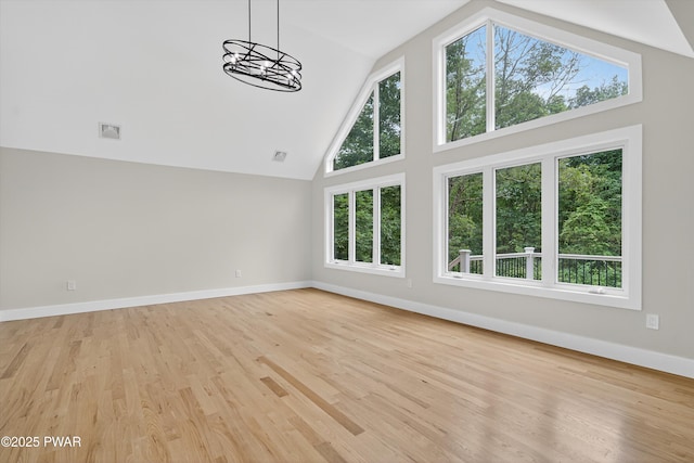120 Milford Estates Dr, Milford, PA 18337 - unfurnished living room featuring high vaulted ceiling, light wood finished floors, and a chandelier