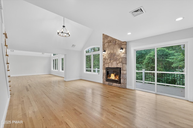 120 Milford Estates Dr, Milford, PA 18337 - unfurnished living room featuring light wood finished floors, a stone fireplace, a chandelier, recessed lighting, and high vaulted ceiling