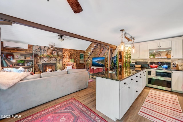 803 Deerfield Rd, Lake Ariel, PA 18436 - kitchen with double oven range, a fireplace, under cabinet range hood, an AC wall unit, and a chandelier