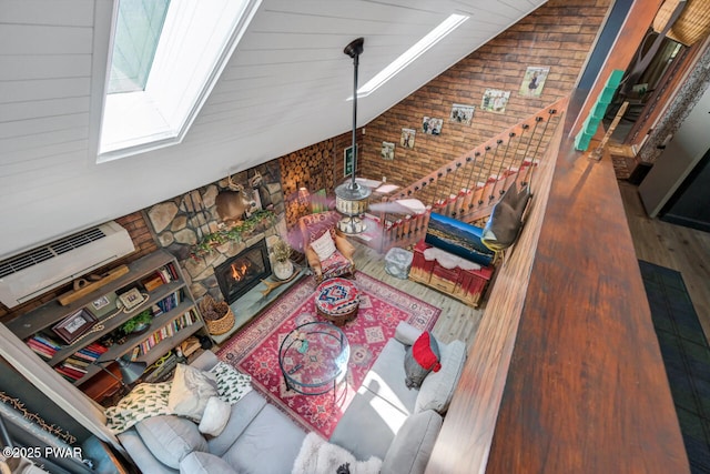 803 Deerfield Rd, Lake Ariel, PA 18436 - living area with wood finished floors, vaulted ceiling, wood walls, a skylight, and a fireplace