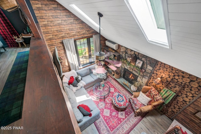 803 Deerfield Rd, Lake Ariel, PA 18436 - living room with a skylight, wood finished floors, wooden walls, a fireplace, and a wall mounted AC