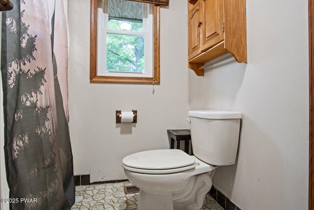 141 Constitution Dr, Lackawaxen, PA 18435 - bathroom featuring toilet, baseboards, and a shower with shower curtain
