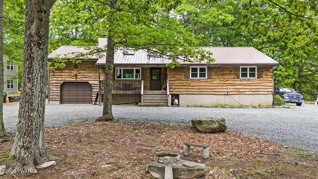 141 Constitution Dr, Lackawaxen, PA 18435 - view of front facade featuring covered porch, a chimney, metal roof, and an attached garage