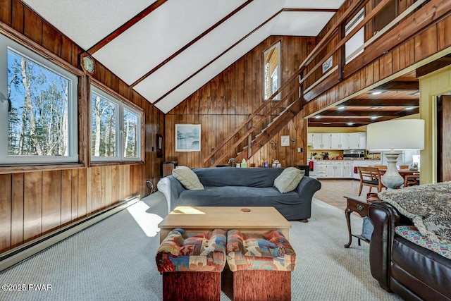 carpeted living room featuring high vaulted ceiling, wood walls, and baseboard heating