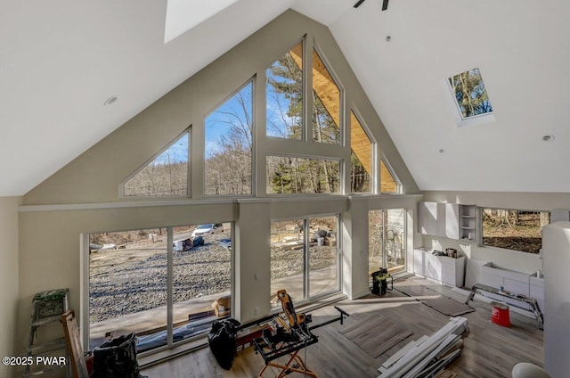 interior space featuring hardwood / wood-style floors, high vaulted ceiling, and built in shelves