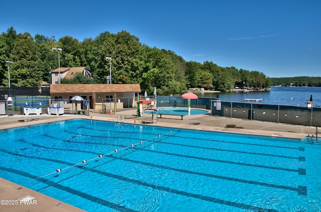 view of pool featuring a patio and a water view