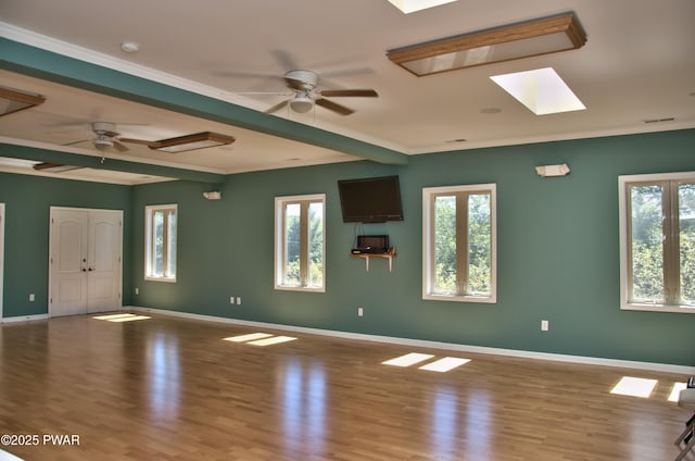 interior space with a healthy amount of sunlight, ceiling fan, light hardwood / wood-style floors, and beamed ceiling