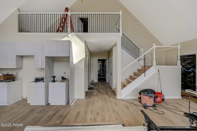 foyer entrance featuring high vaulted ceiling and light hardwood / wood-style floors