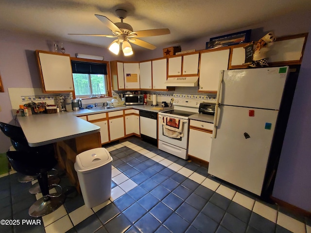 188 Forest Ridge Dr, Hawley, PA 18428 - kitchen with white appliances, under cabinet range hood, a peninsula, backsplash, and ceiling fan