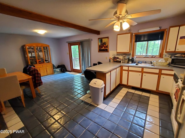 188 Forest Ridge Dr, Hawley, PA 18428 - kitchen featuring stainless steel microwave, a peninsula, plenty of natural light, light countertops, and beamed ceiling