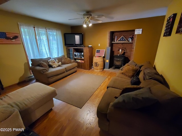 188 Forest Ridge Dr, Hawley, PA 18428 - living area with wood finished floors, a ceiling fan, and a wood stove