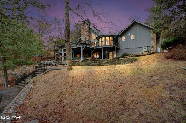 back house at dusk with a deck