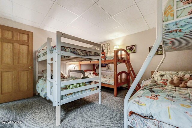 carpeted bedroom with a drop ceiling