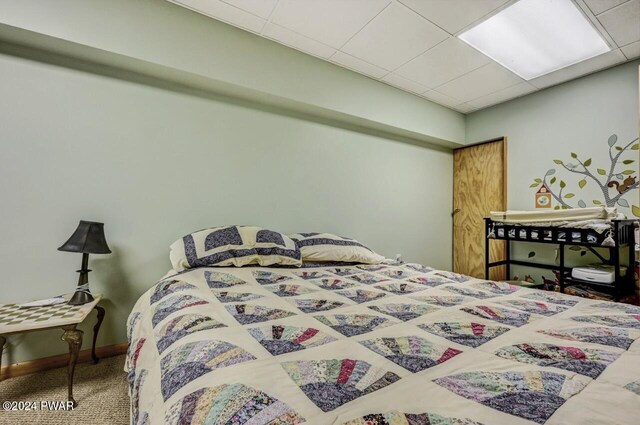 carpeted bedroom with a drop ceiling