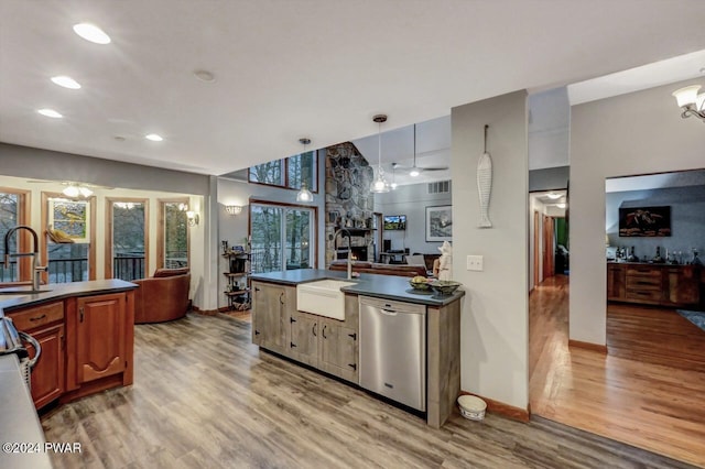 kitchen with pendant lighting, sink, dishwasher, and light wood-type flooring