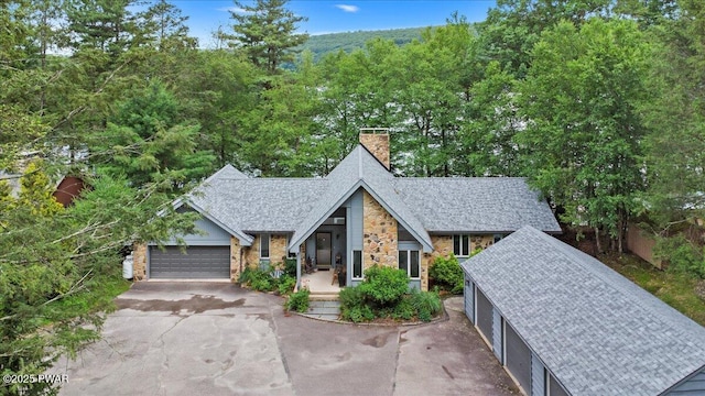 122 Waterfront Dr, Greentown, PA 18426 - view of front of property with a chimney, asphalt driveway, stone siding, a shingled roof, and an attached garage