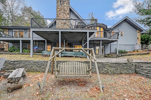 back of house featuring a wooden deck and a patio area