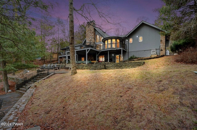 122 Waterfront Dr, Greentown, PA 18426 - back of house at dusk with a chimney, stairway, a deck, and a lawn