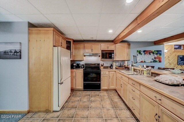 kitchen featuring light brown cabinetry, sink, black appliances, and a drop ceiling