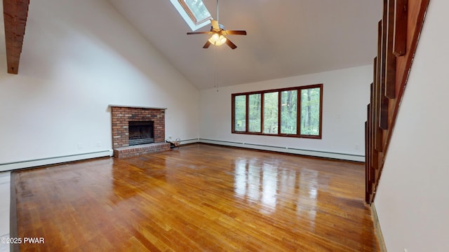 158 Wild Meadow Dr, Milford, PA 18337 - unfurnished living room with baseboard heating, ceiling fan, high vaulted ceiling, a skylight, and wood finished floors
