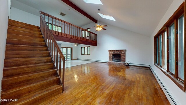 158 Wild Meadow Dr, Milford, PA 18337 - unfurnished living room with a ceiling fan, a baseboard heating unit, a skylight, beam ceiling, and wood finished floors