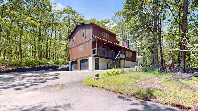 158 Wild Meadow Dr, Milford, PA 18337 - view of front of property with stairs, an attached garage, driveway, and a chimney