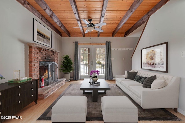 living room featuring a fireplace, ceiling fan, wood ceiling, light wood-type flooring, and french doors