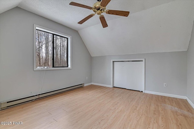 bonus room with lofted ceiling, a textured ceiling, a baseboard radiator, ceiling fan, and light hardwood / wood-style floors