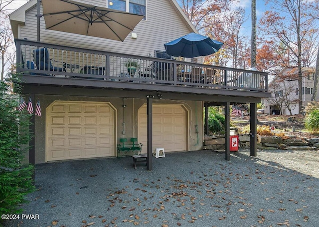 back of property featuring a garage and a deck