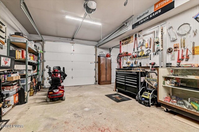 garage with a workshop area and a garage door opener