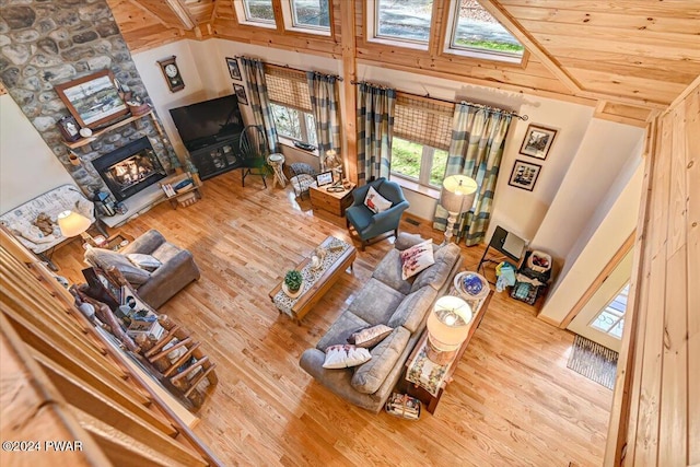 living room with a fireplace, hardwood / wood-style floors, high vaulted ceiling, and wood ceiling