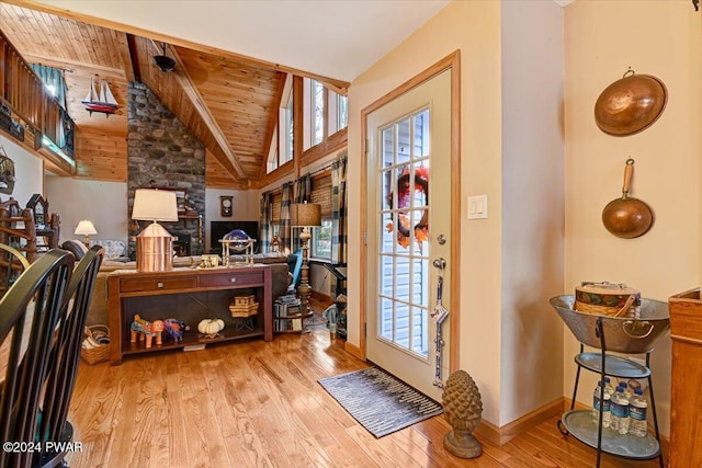 foyer with light hardwood / wood-style flooring, wooden ceiling, and vaulted ceiling