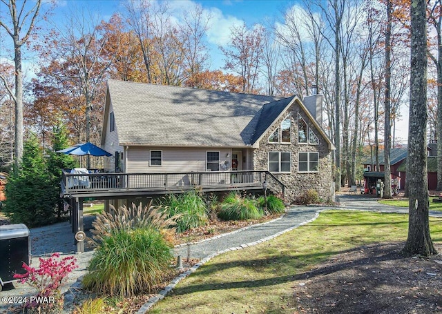 view of front of house with a wooden deck and a front lawn