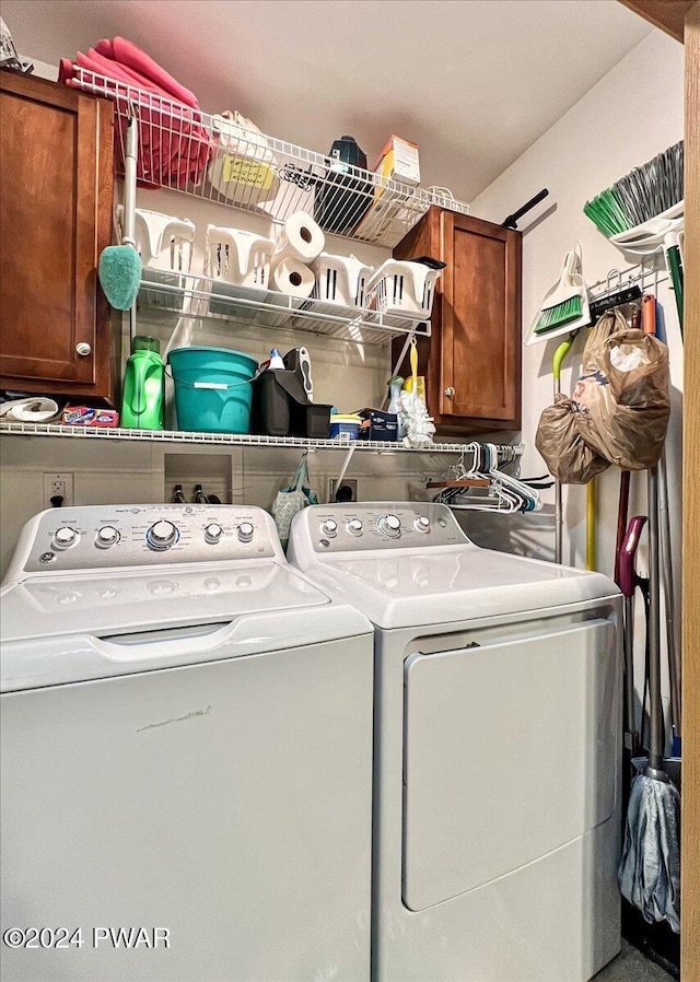 washroom with washer and clothes dryer and cabinets