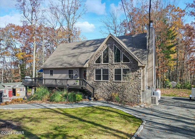 view of front facade with a deck and a front lawn