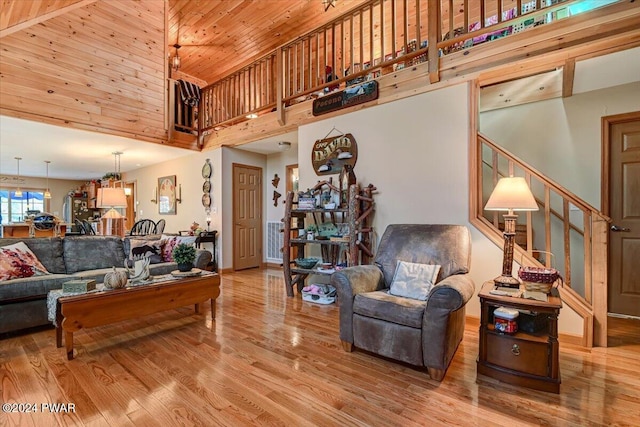 living room with wood-type flooring, a towering ceiling, and wooden ceiling