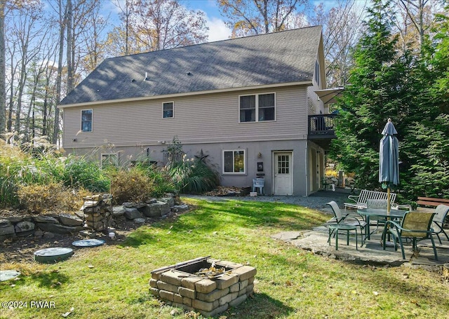 rear view of house featuring a fire pit, a yard, and a patio