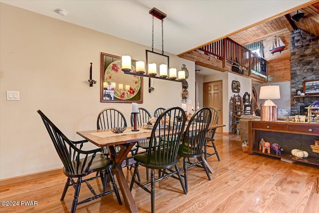 dining area featuring a towering ceiling and light wood-type flooring