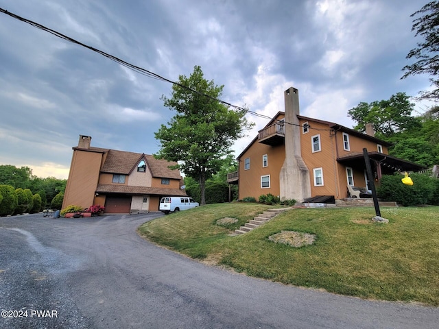 view of side of property featuring a yard and a garage