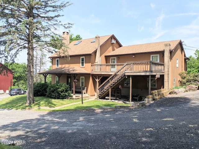 rear view of property with a yard and a deck