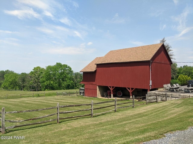 view of outbuilding with a rural view and a yard