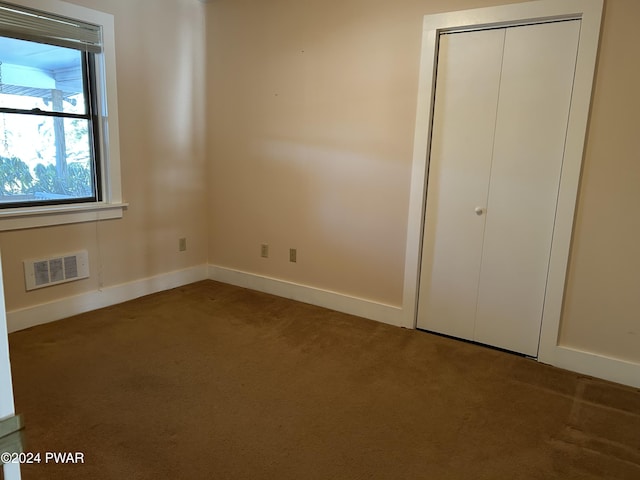 unfurnished bedroom with carpet flooring and a closet