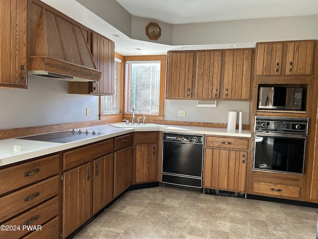 kitchen with black appliances, sink, and premium range hood