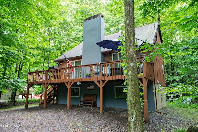 rear view of property featuring a wooden deck