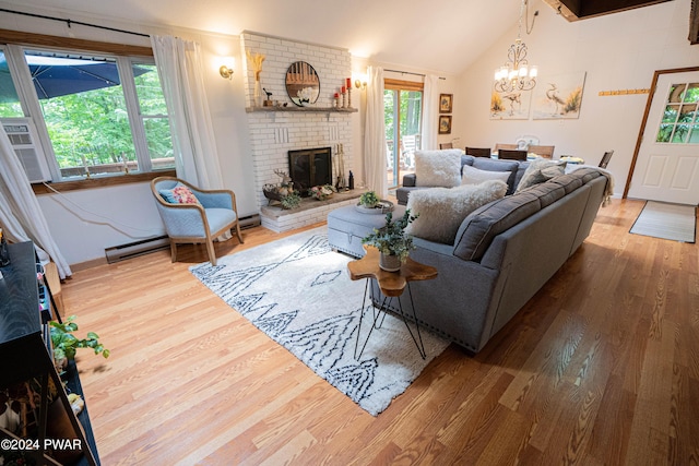 living room featuring a brick fireplace, a baseboard heating unit, a chandelier, lofted ceiling, and hardwood / wood-style flooring