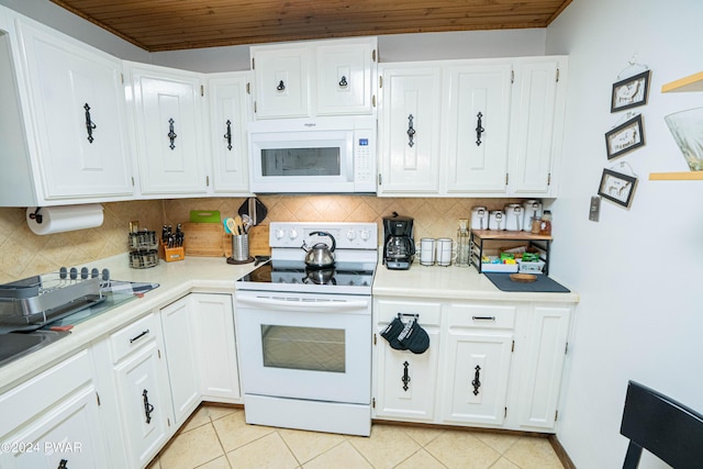 kitchen with decorative backsplash, light tile patterned floors, white appliances, and white cabinetry