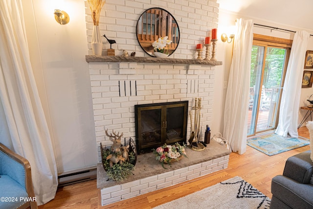 living room featuring a fireplace, hardwood / wood-style flooring, and baseboard heating