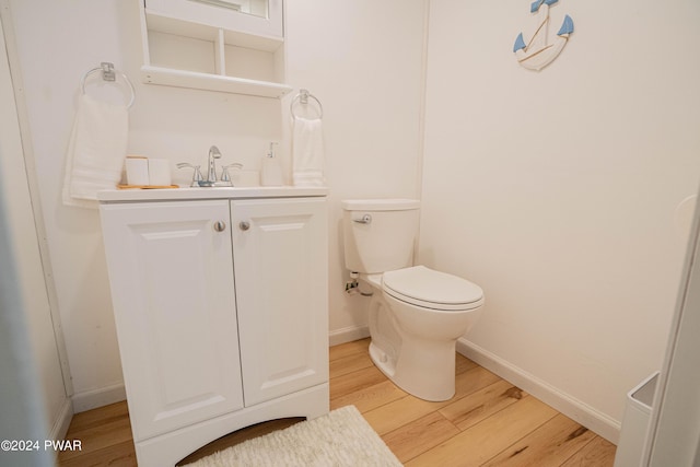 bathroom with hardwood / wood-style floors, vanity, and toilet