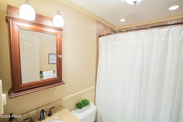 bathroom with curtained shower, crown molding, sink, and toilet